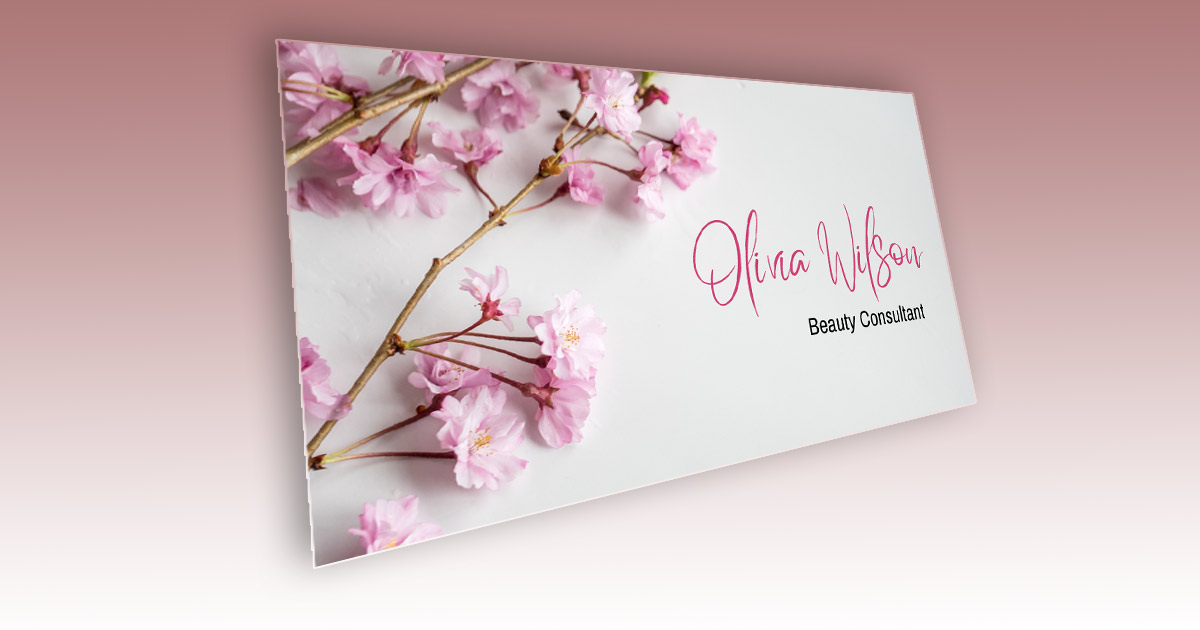 A white business card for a Beauty Consultant. The name is in a pink cursive font, title is in black and there are pink Sakura cherry flower branches on the card as well.