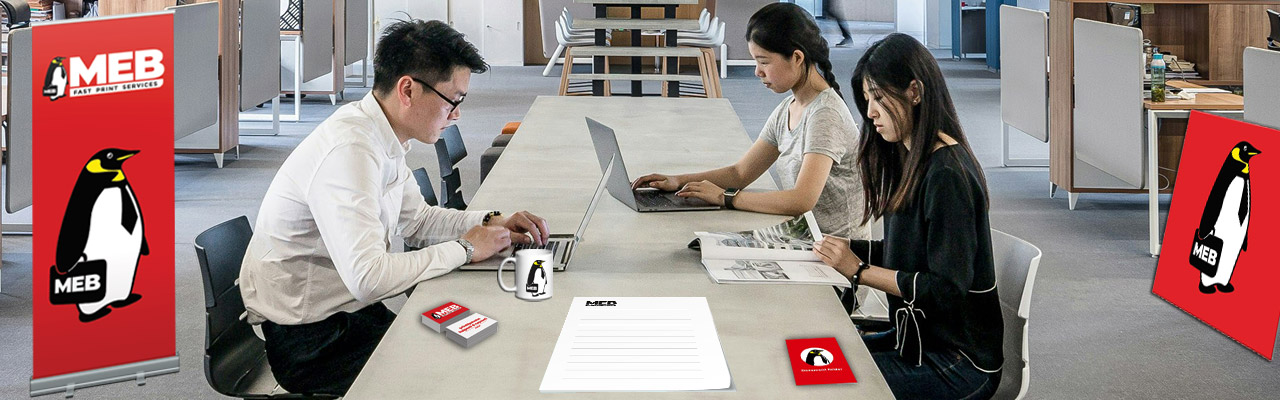 An office and its workers around a table, surrounded by MEB printing products