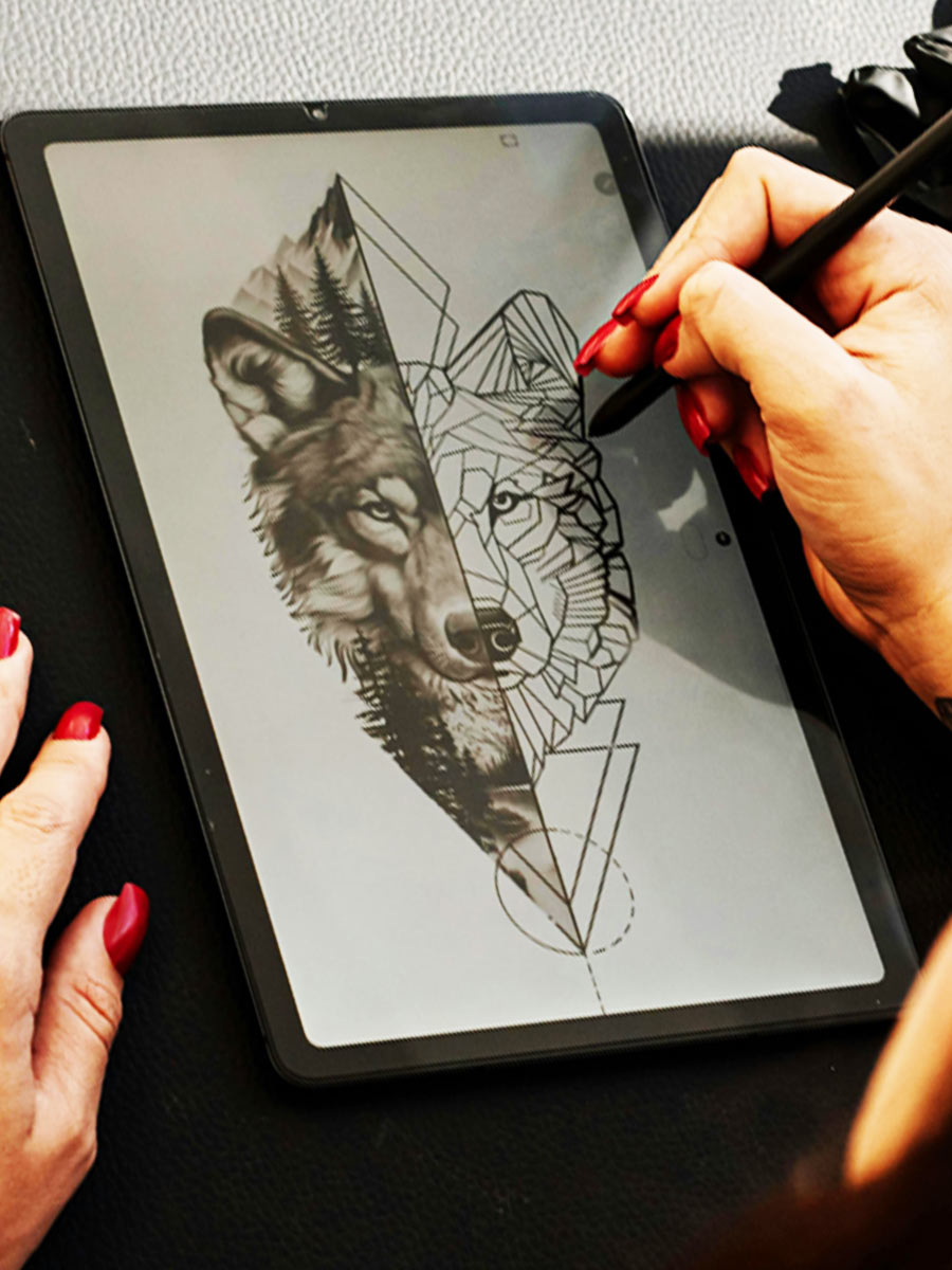 An artist making a piece on a wolf, combining traditional art with a more abstract style, dividing the face in two